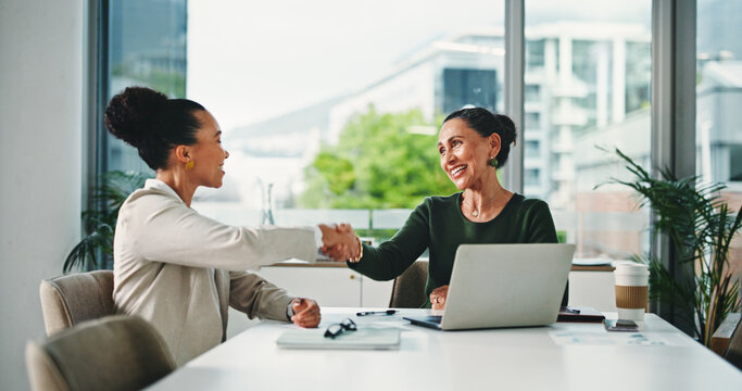 Handshake, meeting and business women for partnership, deal or thank you in office. B2B merger, laptop or shaking hands for welcome, congratulations or client introduction for collaboration agreement