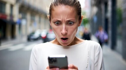 Young adult woman reacting with shock while reading a message on smartphone in a city street, surprise and urgent news concept for communication, finance alert or social media notification - Powered by Adobe