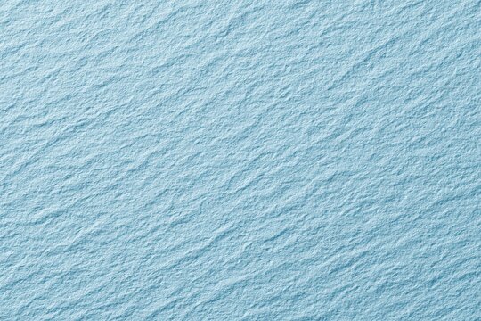 Textured surface in light blue hue showcasing depth and dimension for backgrounds, wallpapers, and design projects, enhancing visual appeal with soft ripples and intriguing detail