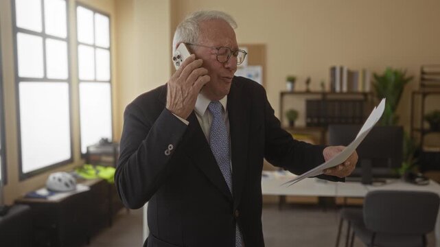 Senior man in business suit talking on phone holding documents in modern office, conveying urgency and professionalism with a focused expression and corporate setting.