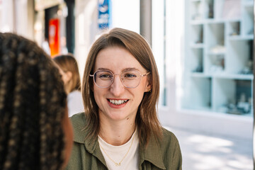Smiling woman having cheerful outdoor conversation with friend