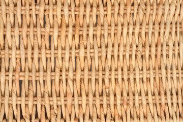 A close-up of a rough surface showcasing the uniform pattern of thick, twisted light-colored natural fibers woven vertically and horizontally.