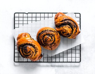 Three freshly baked, spiral pastries with poppy seeds