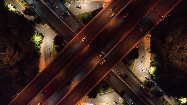 Night aerial panorama of highway intersection in Kunming, Yunnan, China with illuminated roads and traffic