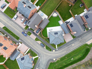 Aerial top down view of newly completed, detached and semi detached private homes seen on once brownfield land in rural Essex, UK. Note the newly laid lawns.
