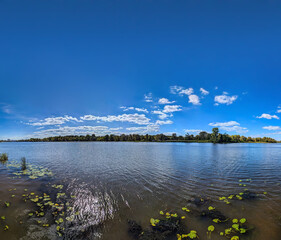 Water and sky banner with copy space inscription.. Blue sky filled many white clouds creating a peaceful and inspiring natural river landscape scene. Several clouds in a some row on the horizon.