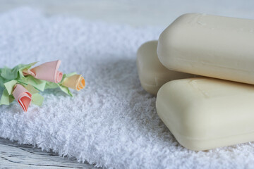 Cream soap. A bar of soap on a white towel on a wooden table, close-up.