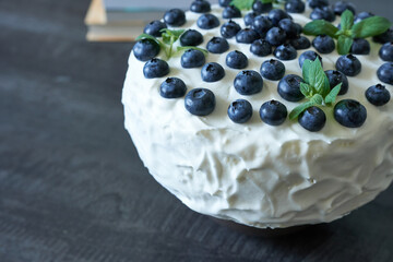 Homemade cake with fresh blueberries and mint on a black background.