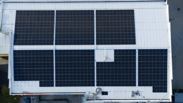 Aerial view of rooftop solar panels on industrial building, clean renewable energy technology for sustainable power generation