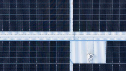 Top-down drone photo of solar energy panels on industrial roof, geometric pattern representing modern green technology
