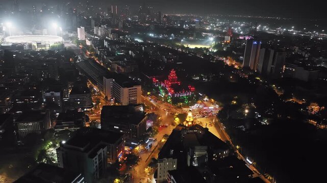 Aerial footage of traffic congestion at Church Gate station with colorful lighting of the Indian flag in the background and a view of the Mumbai skyline featuring high-rise buildings in South Mumbai