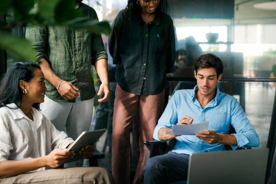 Team of industrial design agency specialists, software engineer programmers discussing in office