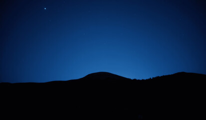 Nighttime tranquility in a vast landscape with distant hills under a starry sky Generative AI