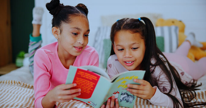Children, relax and reading book on bed with love, care and learning for bonding in home. Family, kids or siblings with fairytale for storytelling, teaching literacy or fantasy for support in bedroom