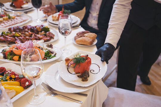 Elegant dining experience unfolds at a lavish event with beautifully arranged dishes and attentive service in an upscale venue during an evening gathering