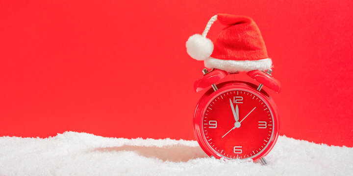 Merry Christmas, saint nicholas day christmas shopping, christmas sale holiday greeting card - countdown, christmas santa hat on red retro alarm clock in snow, isolated on red background - Powered by Adobe