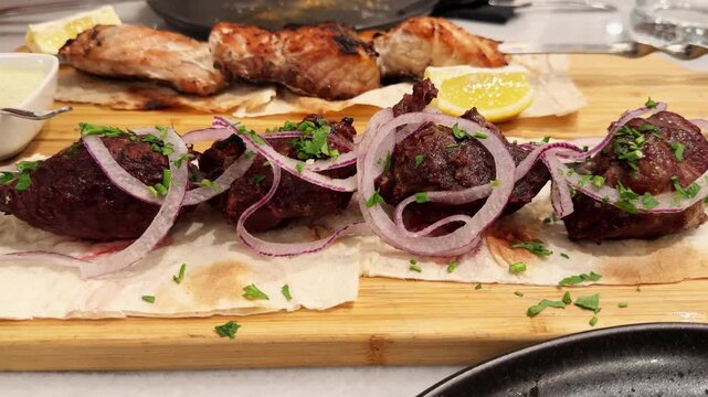 Beef shashlik, cooked over coals on pita bread, served with sauce, onion and greens. High quality 4k footage