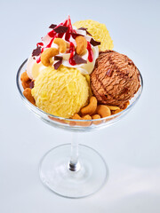  Eiskugeln Vanille und Schokolade mit Sahnetupfer mit Erdbeersauce und Cashew Kernen, isoliert, Eisbecher, Schokoladeneis, 