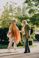 Fototapeta premium Two senior women walking and talking in a park