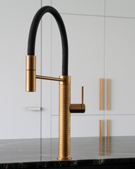 Modern golden kitchen faucet on black marble countertop