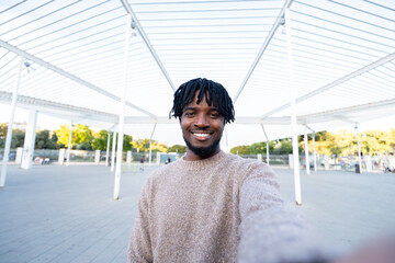Happy young black man taking urban selfie