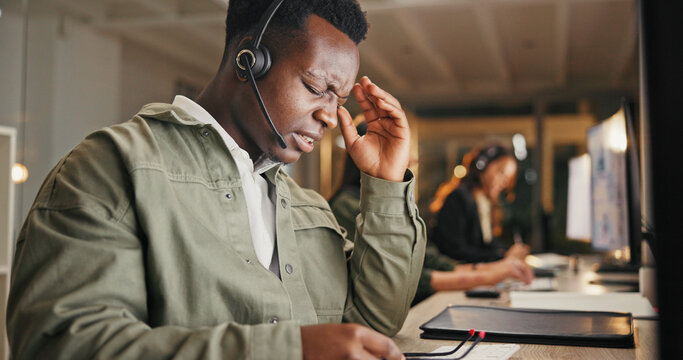 Call center, customer service and man in office with burnout from headache, telecom or working overtime. Late, tired male person and migraine at night with client complaint, bad review or mistake - Powered by Adobe
