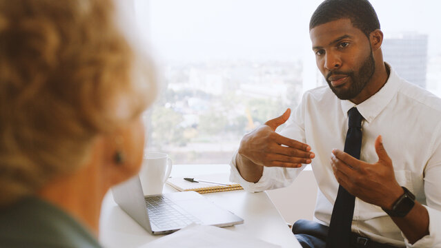 Close Up Of Woman Meeting With Male Financial Advisor In Office And Signing Contract