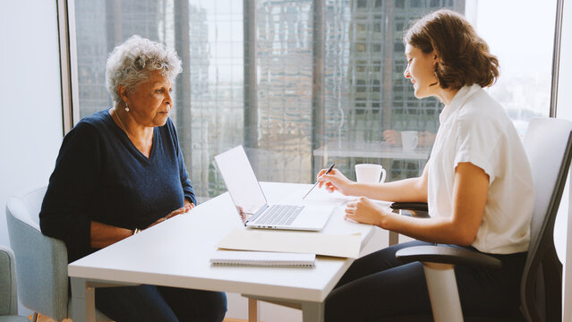 Senior Woman Meeting With Male Financial Advisor In Office