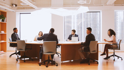 Group Of Business Professionals Meeting Around Table In Modern Office