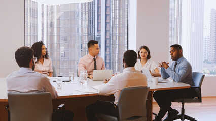 Group Of Business Professionals Meeting Around Table In Modern Office