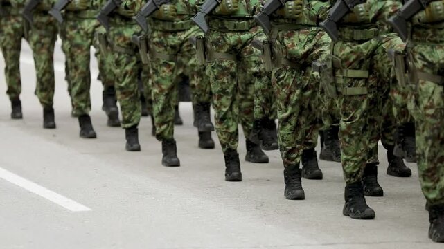 Soldiers in camouflage uniform march and holding rifle weapon gun forces military national day