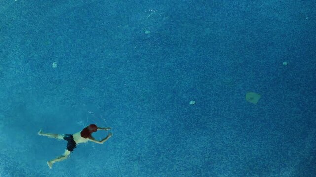 Sousse, Tunisia A man swims in a blue pool at night. 