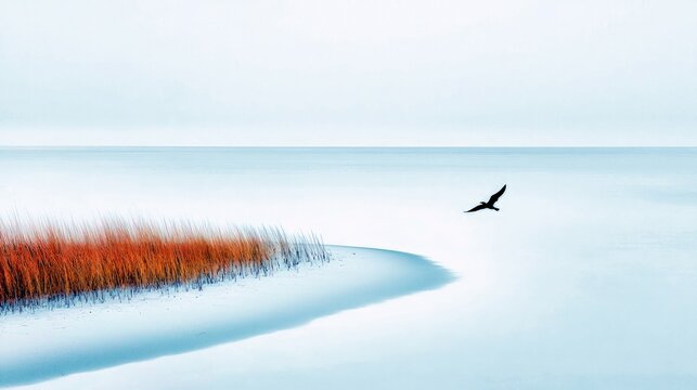 A solitary bird flies over tranquil blue ocean waters next to a sandy shore with bright orange reeds. - Powered by Adobe