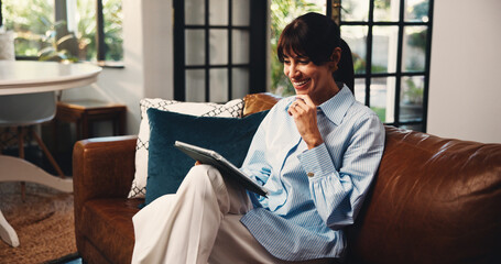 Fototapeta na wymiar Tablet, thinking and woman in home for remote work, article idea or inspiration for newsletter. Technology, mature copywriter and happy freelancer in living room for planning story and reading email