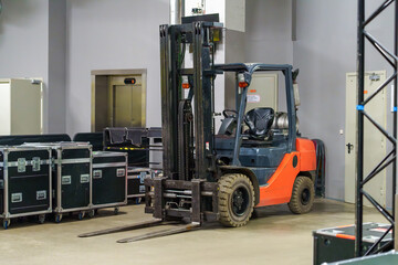 Small industrial forklift on the venue backstage used for transporting heavy equipment and stage materials during concert setup