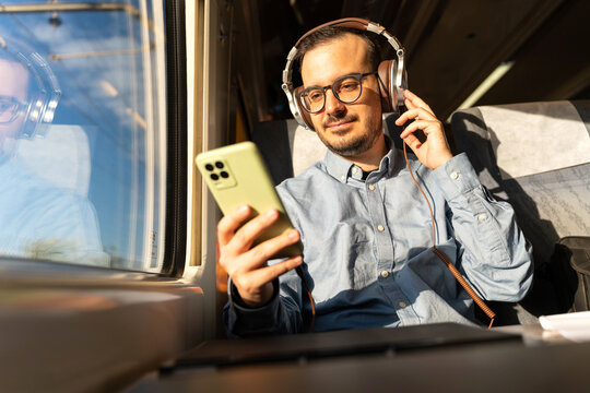 Man traveling by train listening to music