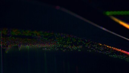 Close-up of a broken TV screen displaying colorful pixel distortion and crack lines from impact.