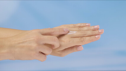 Close up of woman hands applying moisturizing cream on her skin, emphasizing skincare and softness. Concept of beauty, skin care, and cream presentation.