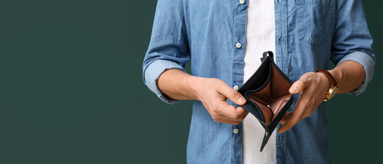 Man holding empty wallet on green background, closeup