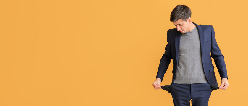 Stressed man with empty pockets on color background. Bankruptcy concept - Powered by Adobe