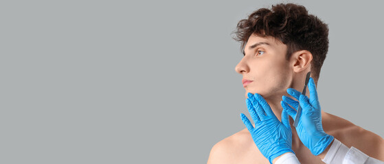 Young man and plastic surgeon with scalpel on grey background, closeup
