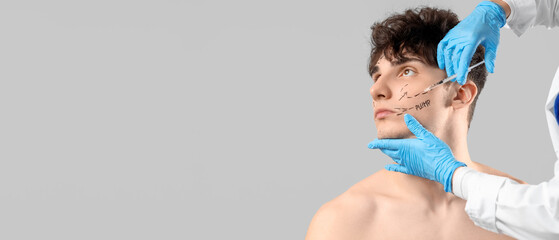Young man receiving injection from plastic surgeon on grey background, closeup