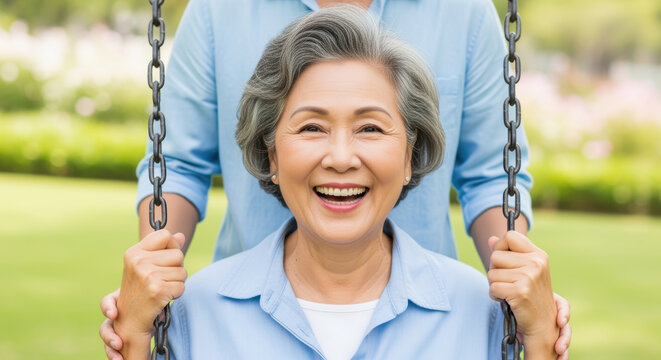 Joyful older woman with gray hair smiling on a swing in a sunlit park, surrounded by greenery and nature on a bright day