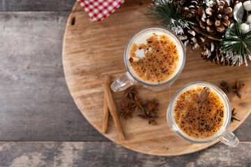 Eggnog with Cinnamon and Christmas Decorations on wooden table. Top view. Copy space