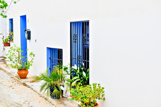 Typical streets and white walls with blue windows and iron grilles in the town of Altea, Alicante, Spain.