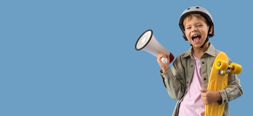 Little boy in helmet, with skateboard and megaphone on blue background with space for text