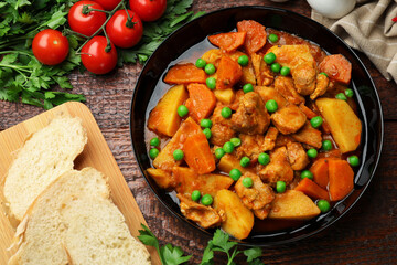 Delicious cooked stew served on wooden table, flat lay