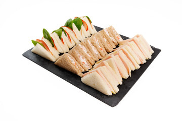 Assortment of finger sandwiches on black slate platter