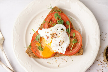 Plate of tasty sandwich with egg on grey background