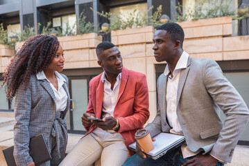 Multiethnic business people having conversation outdoors during coffee break